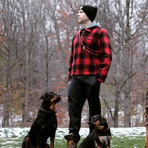 Nick in a flannel shirt with two dogs