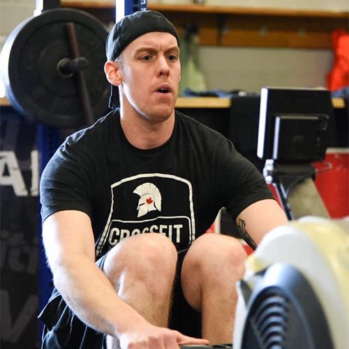 Steve working out on a rowing machine with a Crossfit Battlefield shirt on